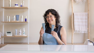 Celine holding two bottles of Face Reality Acne Med with products on shelf in the background