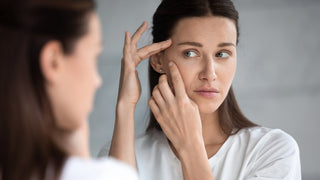 Woman stretching skin and inspecting in mirror