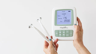 Hands holding up a MyoLift TriWave microcurrent device with probes