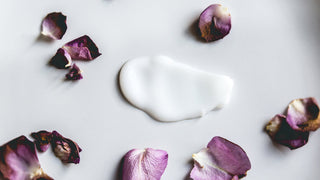 Flower petals surrounding a skincare product swatch