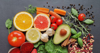 Lettuces, carrots, apple, citrus, avocado on a cutting board