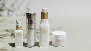 line up of four skincare products with leaf shadow in background