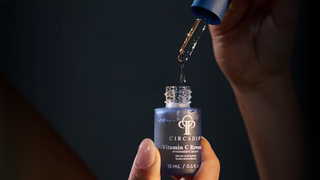 hand holding a bottle and dropper of CIrcadia Vitamin C Reversal Serum