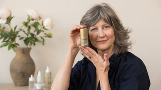 Jeana LeClerc, founder of Art of Skin Care, holding a bottle of ( plated )™ Skin Science INTENSE Serum, a regenerative skincare exosome serum
