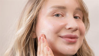 Woman applying acne-safe hydrating gel to support skin barrier during acne treatment