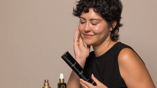 Woman with radiant skin holding Anfisa An-Dew.