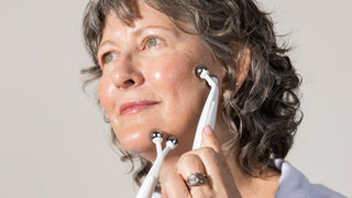 Jeana holding the Myolift Triwave Microcurrent probes on her jawline.