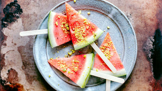 A plate of watermelon slices on sticks