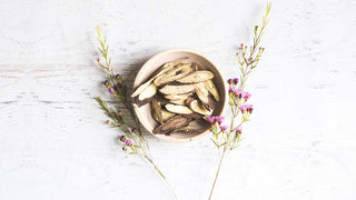 licorice root in a bowl with flowers on the side