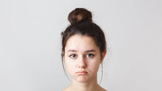 A woman with maturation arrest acne on her forehead. She looks bummed.