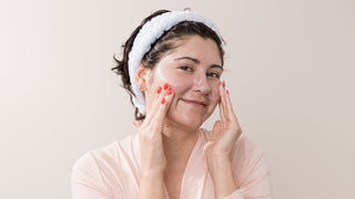 Celine holds several Face Reality Cleansers in her hands.