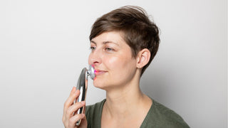 woman holding ultrasound and led skincare tool to lip area