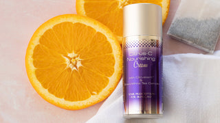 A Skin Script Citrus-C Nourishing Cream sits on a table with a tea bag and orange slices.