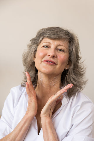 Jeana applying HOP+ PLLA Volume Boost Moisturizer to her neck.