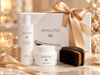 Epicutis Bodycare Simplified Holiday Gift Set featuring Lipid Body Treatment, Body Scrub, and Cecily Braden Lymphatic Brush displayed in front of a white gift box with a champagne gold ribbon.