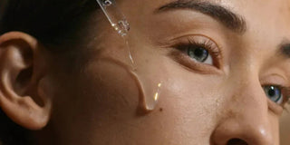 Close-up of serum dropper applying drop near woman's eye and cheek – clarifying serum for visible pores and excess oil