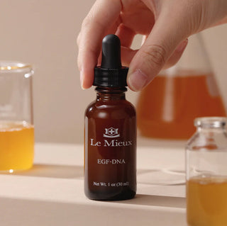 Le Mieux EGF-DNA advanced treatment serum in amber dropper bottle with warm-toned skincare background.