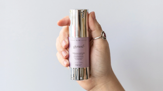 A person holds a GlyMed Plus Serum in their hands.