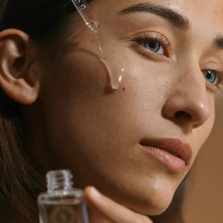 Woman applying Sorella Main Squeeze Serum to her cheek to balance oil production and minimize pores.