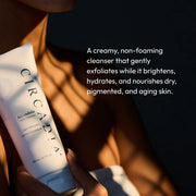 Hand holding Circadia Amandola Milk Cleanser in golden light — creamy non-foaming cleanser that brightens, hydrates, and nourishes dry, pigmented, and aging skin