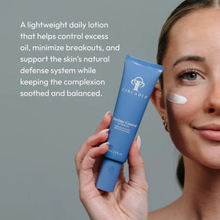 Woman applying Circadia Daytime Control Oil Reducer to her cheek, a lightweight daily lotion that controls excess oil, minimizes breakouts, and balances the complexion