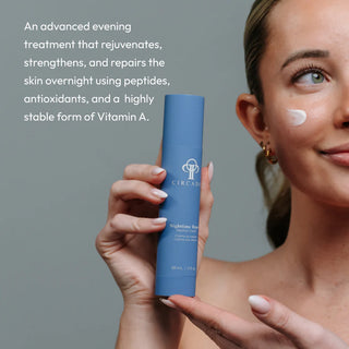Woman holding Circadia Nighttime Repair Retinol Cream with cream applied to cheek — advanced overnight retinol treatment that rejuvenates, strengthens, and repairs aging skin