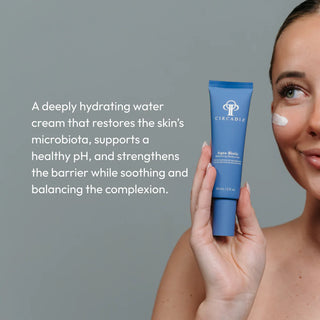 Woman applying Circadia Aqua-Biotic Balancing Moisturizer to her cheek, a deeply hydrating water cream that restores the microbiota, supports healthy pH, and strengthens the skin barrier