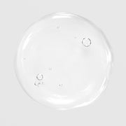 Close-up of Hale & Hush Remedy Rehab Oil showing a lightweight, clear oil texture with small bubbles on a light gray background