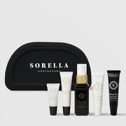 Sorella Apothecary Recovery Kit with black cosmetic bag and five travel-size products: Lemon Lightening Serum, Blueberry Milk Moisturizer, Orange You Jelly Cleanser, Quench and Protect Hydrating SPF 30, and Salving Grace Recovery Ointment