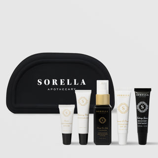 Sorella Apothecary Recovery Kit with black cosmetic bag and five travel-size products: Lemon Lightening Serum, Blueberry Milk Moisturizer, Orange You Jelly Cleanser, Quench and Protect Hydrating SPF 30, and Salving Grace Recovery Ointment