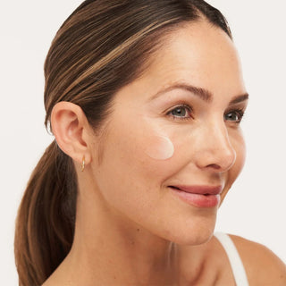 Woman applying ALASTIN C-RADICAL Defense Antioxidant Serum to cheek