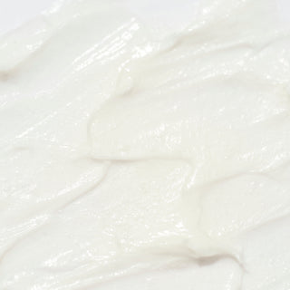 Close-up of Corthe Cleansing Foam showing a rich, creamy white foam texture on a light background