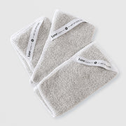 Art of Skin Care Luxe Cloth set of three grey microfibre cleansing cloths with white branded labels, fanned out on white background