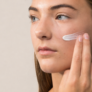Woman applying Face Reality clearDerma Moisturizer to cheek – lightweight non-comedogenic moisturizer for acne-prone skin