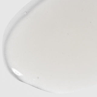 Close-up of Hale & Hush Soothe Essence showing a lightweight, milky white essence texture on a light gray background