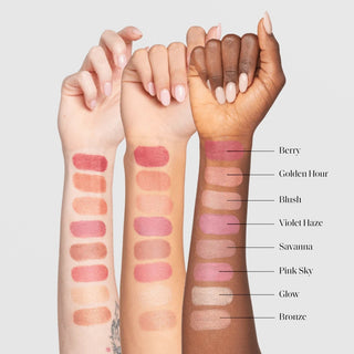 Colorescience Sunforgettable Total Protection Color Balm SPF 50 shade swatches shown on three arms with fair, medium, and deep skin tones displaying eight shades: Berry, Golden Hour, Blush, Violet Haze, Savanna, Pink Sky, Glow, and Bronze on a light gray background