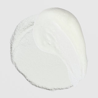 Close-up of Corthe Dermo Essential Super Enzyme Powder showing dry white powder alongside its lathered foam texture on a light gray background