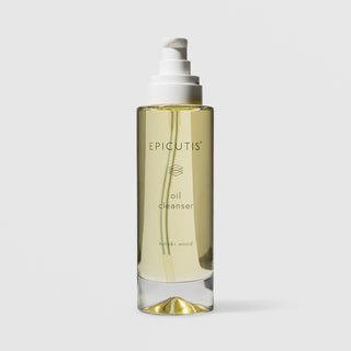 Epicutis Oil Cleanser hinoki wood scent in a clear glass pump bottle with golden-toned oil visible inside, on a light gray background
