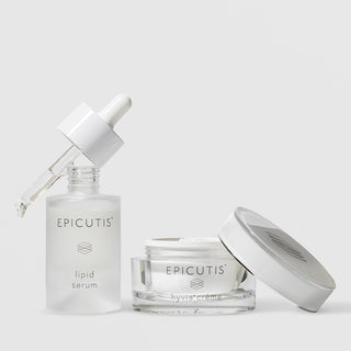 Epicutis Lipid Serum dropper bottle and Hyvia Crème open glass jar luxury skincare set with lid off, on a light gray background