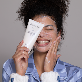 Smiling woman lathering Face Reality Barrier Balance Creamy Cleanser – gentle daily calming face wash for acne-prone skin