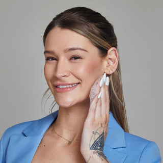 Smiling woman lathering Face Reality L-Mandelic Face and Body Wash on cheek – brightening AHA cleanser for clear skin