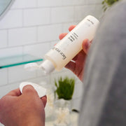 Hands dispensing Face Reality Sal-C Toner onto a cotton pad – salicylic acid toner for pore refinement and acne-prone skin