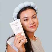 Smiling woman applying Face Reality Antioxidant Scrub to her face – exfoliating acne-safe face scrub for smooth skin