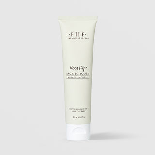 Farmhouse Fresh Moon Dip Back to Youth Ageless Mousse travel tube (2 fl oz / 71 ml) in a soft sage green squeeze tube with a white cap, labeled as a peptide-enriched skin therapy, displayed against a light gray background.