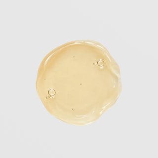 GlyMed Plus Elite Brilliant Tone texture swatch showing lightweight golden gel consistency with air bubbles on light gray background