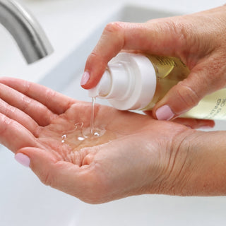 GlyMed Plus Illuminating Cleansing Oil being pumped into palm, lightweight facial cleansing oil