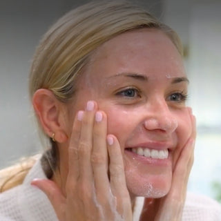 Woman massaging GlyMed Plus Illuminating Cleansing Oil into a lather on face, brightening oil cleanser