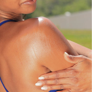 GlyMed Plus Pure Glow SPF 60 Oil applied to shoulder outdoors, glow-finish body sunscreen oil