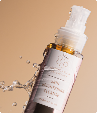 Skincare bottle labeled 'Skin Brightening Cleanse' with water droplets on a beige background