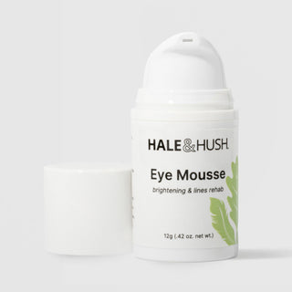Hale & Hush Eye Mousse brightening and lines rehab eye cream in a white airless pump bottle with cap removed and green leaf botanical design, 12g / 0.42 oz, on a light gray background